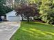 Charming home featuring a well-manicured lawn, mature tree, and an attached two-car garage at 1920 Waldeck Ct, Mount Pleasant, NC 28124