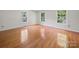 Bright bedroom with gleaming hardwood floors and three windows creating a warm and inviting atmosphere at 2020 Dawnshire Dr, Gastonia, NC 28054