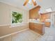 Charming kitchen with natural wood cabinets, tile flooring, and a large window overlooking lush trees at 2020 Dawnshire Dr, Gastonia, NC 28054