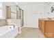 Well-lit bathroom boasting a soaking tub, glass shower, and vanity with storage at 2275 Laurens Dr, Concord, NC 28027