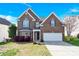Charming two-story brick home with manicured lawn and attached two-car garage on a beautiful sunny day at 2275 Laurens Dr, Concord, NC 28027