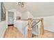Hallway with wood floors leads to rooms with natural light and features wood railing and modern lighting at 2333 Greenland Ave, Charlotte, NC 28208