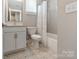 Bright bathroom with a patterned tile floor, a white vanity, toilet, and tub with shower at 2969 Simpson Dr, Charlotte, NC 28205