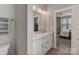 Modern bathroom featuring a double vanity with white cabinetry, quartz countertops, and an open doorway to the bedroom at 2969 Simpson Dr, Charlotte, NC 28205