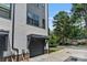 Close exterior shot of the townhome garages, featuring gray doors, stone accents, and freshly landscaped yard at 2969 Simpson Dr, Charlotte, NC 28205