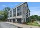 Close view of the townhome garages and the exterior which features gray siding, stone accents, and manicured landscaping at 2969 Simpson Dr, Charlotte, NC 28205