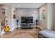 Comfortable living room featuring hardwood floors, speakers, a TV, and a beautiful blossom mural at 2969 Simpson Dr, Charlotte, NC 28205