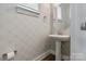Stylish powder room with a pedestal sink, patterned wallpaper, and modern fixtures at 2969 Simpson Dr, Charlotte, NC 28205