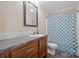 Bathroom with a vanity featuring a dark wood cabinet, white tiles, and a blue shower curtain at 308 Laurel Ridge Dr, Lincolnton, NC 28092