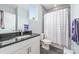 Bright bathroom with granite countertops, white cabinets, stylish mirror, and a patterned shower curtain at 327 S Turner Ave, Charlotte, NC 28208