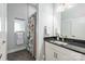 Bathroom features a black granite vanity, white cabinets, and a shower with colorful curtain at 327 S Turner Ave, Charlotte, NC 28208