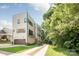Modern three-story townhouse with a neutral facade, balcony, and an attached garage and long driveway at 327 S Turner Ave, Charlotte, NC 28208