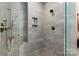 Modern shower featuring gray tiling, built in shelving, and upscale shower head and faucet at 327 S Turner Ave, Charlotte, NC 28208