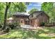 Large backyard with a patio and lush greenery surrounding the brick home at 3730 Monique Ln, Charlotte, NC 28210