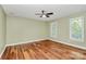 Bedroom featuring hardwood floors, a ceiling fan, and white-trim windows at 3730 Monique Ln, Charlotte, NC 28210