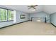 Large bedroom with neutral carpet, two windows, and ceiling fan at 3730 Monique Ln, Charlotte, NC 28210
