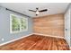 This bedroom features beautiful hardwood floors, a wooden accent wall, and a ceiling fan at 3730 Monique Ln, Charlotte, NC 28210