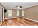 Spacious bedroom with hardwood floors, a ceiling fan, and multiple windows at 3730 Monique Ln, Charlotte, NC 28210