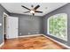 Cozy bedroom with hardwood floors, a ceiling fan, and a large window at 3730 Monique Ln, Charlotte, NC 28210