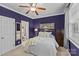 Bedroom with purple walls, white bed, and bathroom access, offering style and convenience at 4263 Rambling Rose Ln # 23, Rock Hill, SC 29732