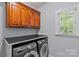 A laundry room with overhead cabinets, countertop, and a front loading washer and dryer at 4263 Rambling Rose Ln # 23, Rock Hill, SC 29732