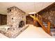Basement showcasing a stone fireplace with metal screen and wood stairs at 4275 Herman Sipe Rd, Conover, NC 28613