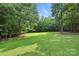 Expansive backyard with lush green grass, mature trees, and plenty of space for outdoor activities at 4824 Waxhaw Farms Rd, Waxhaw, NC 28173
