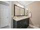 Updated bathroom with a dark vanity, quartz countertops, decorative mirror, and modern fixtures at 4824 Waxhaw Farms Rd, Waxhaw, NC 28173