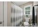 Bright bathroom with modern shower curtain, tiled walls, updated fixtures, and a clean aesthetic at 4824 Waxhaw Farms Rd, Waxhaw, NC 28173