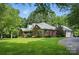 A beautiful brick home featuring a lush lawn, mature trees, and a charming side-entry garage at 4824 Waxhaw Farms Rd, Waxhaw, NC 28173