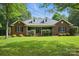 Charming brick home with well-manicured lawn and inviting front porch, complemented by lush green landscaping at 4824 Waxhaw Farms Rd, Waxhaw, NC 28173