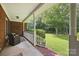 A cozy front porch featuring brick columns, seating, and views of the landscaped front yard and mature trees at 4824 Waxhaw Farms Rd, Waxhaw, NC 28173