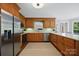 A kitchen featuring stainless appliances, custom wood cabinetry, and tile backsplash offering ample cooking space at 4824 Waxhaw Farms Rd, Waxhaw, NC 28173