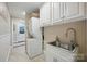 Convenient laundry room with stacked washer/dryer and utility sink at 4824 Waxhaw Farms Rd, Waxhaw, NC 28173