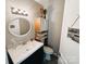 Half bathroom features vanity with sink and storage, wood cabinet and decorative mirror at 5017 Celeste Ct, Charlotte, NC 27609