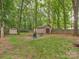 Enjoy this private backyard with a fire pit and storage shed, all surrounded by mature trees and greenery at 5109 Walnut Grove Ln, Charlotte, NC 28227