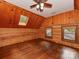 Bedroom features hardwood floors, wooden walls, and natural light streaming through the skylight and the two windows at 5109 Walnut Grove Ln, Charlotte, NC 28227