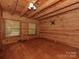 Spacious bedroom with hardwood floors, wooden walls, wooden ceiling and natural light streaming through the two windows at 5109 Walnut Grove Ln, Charlotte, NC 28227