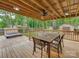 Inviting covered deck features outdoor dining space and hot tub for relaxation in a wooded backyard at 5109 Walnut Grove Ln, Charlotte, NC 28227