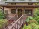 Inviting log cabin front porch with wooden steps, lush greenery, and rustic charm at 5109 Walnut Grove Ln, Charlotte, NC 28227