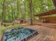 Enjoy this backyard hot tub, featuring a covered deck, fire pit, and storage shed nestled among mature trees at 5109 Walnut Grove Ln, Charlotte, NC 28227