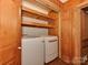This charming laundry room features a washer, dryer, and shelving for easy laundry at 5109 Walnut Grove Ln, Charlotte, NC 28227