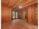 A spacious living room features hardwood floors, wood-paneled walls, an access door, and sliding doors to the outside at 5109 Walnut Grove Ln, Charlotte, NC 28227