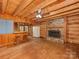 Open living room with wood floors, ceiling fan, fireplace, and bar area with stools at 5109 Walnut Grove Ln, Charlotte, NC 28227