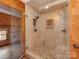 This is a full bathroom shower with stylish stone tile and bronze fixtures at 5109 Walnut Grove Ln, Charlotte, NC 28227