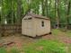 A small storage shed with a window and double doors, complemented by surrounding trees and a wooden fence at 5109 Walnut Grove Ln, Charlotte, NC 28227