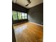 This bedroom features a ceiling fan, hardwood floors, neutral paint and a large window at 514 W 10Th St # 403, Charlotte, NC 28202