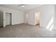 Spacious bedroom with neutral carpet, ceiling fan, and access to the bathroom and closet at 54 Reed Ne St, Concord, NC 28025