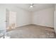 Bedroom featuring neutral carpet, a ceiling fan, and access to the bathroom and walk-in closet at 54 Reed Ne St, Concord, NC 28025