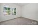 Bright bedroom with neutral walls, carpet, and trim, featuring dual windows at 54 Reed Ne St, Concord, NC 28025
